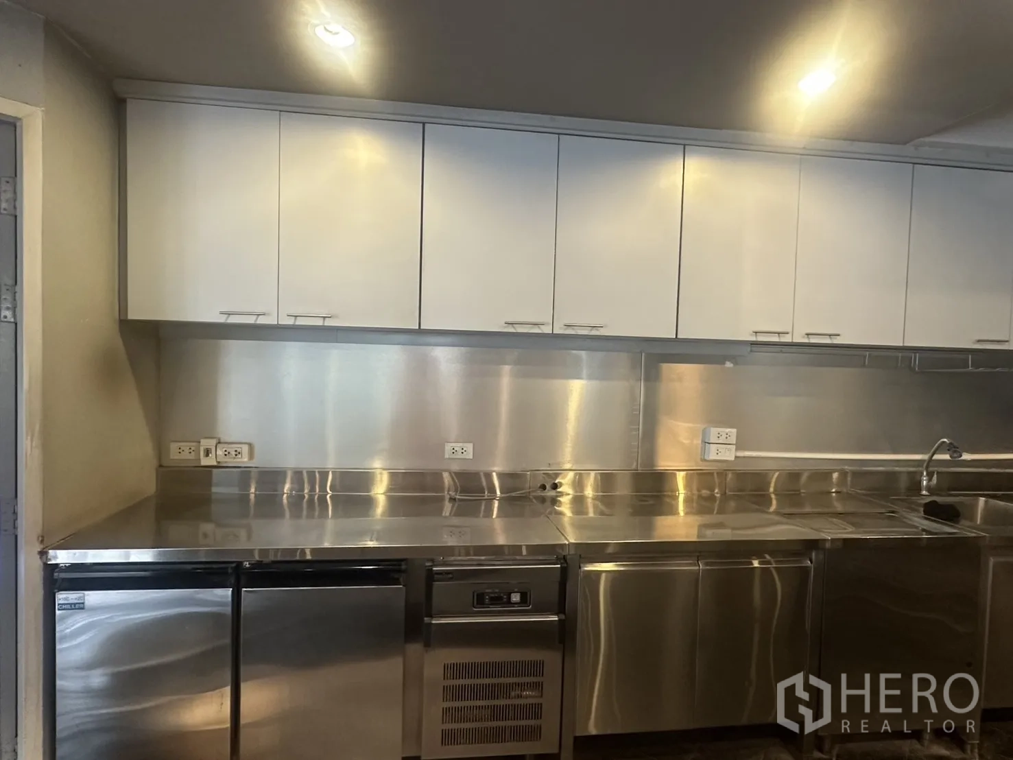 Retail Space for rent in Watthana, Bangkok - Stainless-steel commercial kitchen with prep counters, sink, upper cabinets, and undercounter fridges.