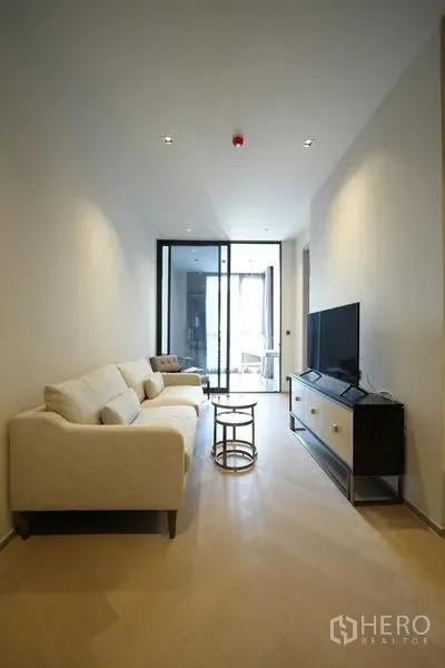 Condominium for rent - Minimalist lounge facing large windows and a sunroom, with neutral walls and recessed lighting.