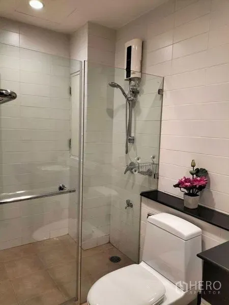 คอนโด ให้เช่าในWatthana, Bangkok - ห้องน้ำปูกระเบื้องขาว มีฉากกั้นกระจก ฝักบัว โถสุขภัณฑ์ และชั้นวาง