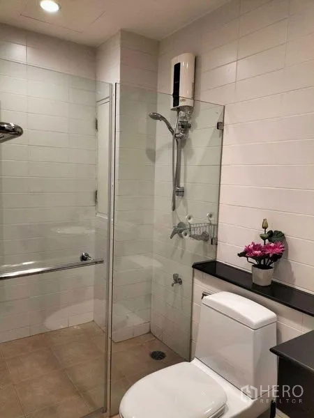 คอนโด ให้เช่าในWatthana, Bangkok - ห้องน้ำปูกระเบื้องขาว มีฉากกั้นกระจก ฝักบัว โถสุขภัณฑ์ และชั้นวาง