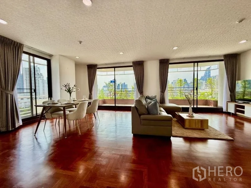 Condominium for rent - Corner living space with dining set and multiple sliding doors opening to a wraparound balcony.