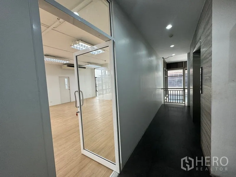 Office Space for rent in Sathon, Bangkok - Glass entry from corridor into bright open‑plan office with wood floors in Sathon, Bangkok.