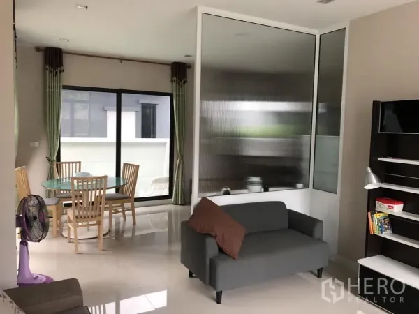 独立式住宅 出租在Saphan Sung, Bangkok - 开放式客厅与用餐区，带玻璃隔断和通往露台的推拉门。