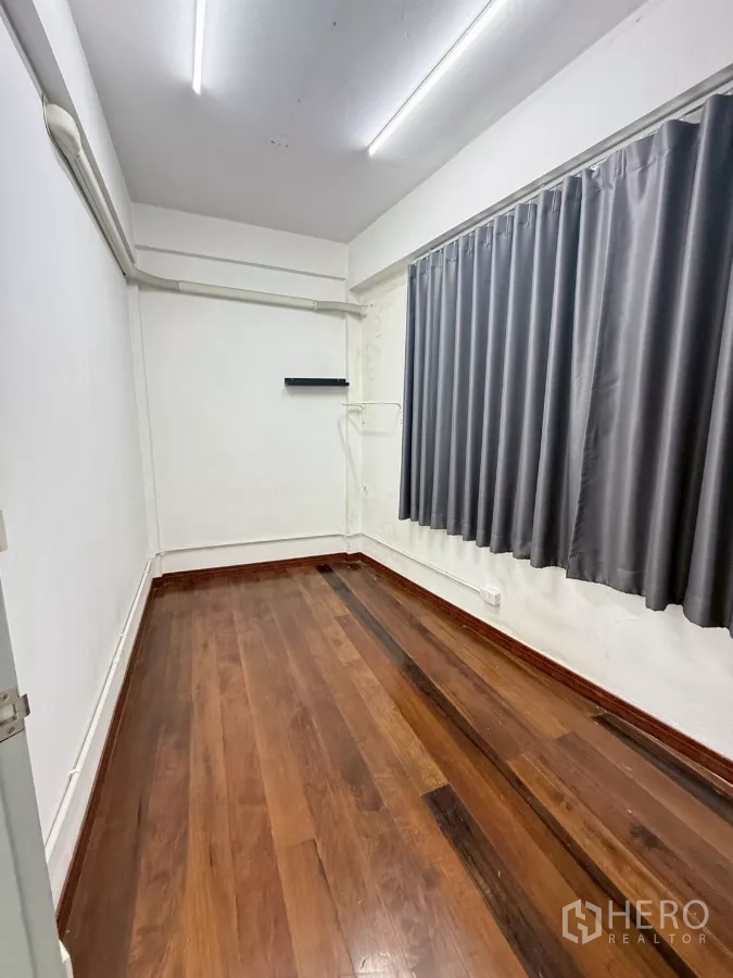 อาคารพาณิชย์ ให้เช่าในKhlong Toei, Bangkok - ห้องทรงยาวพื้นไม้ ผ้าม่านสีเทา และสายไฟเดินลอย