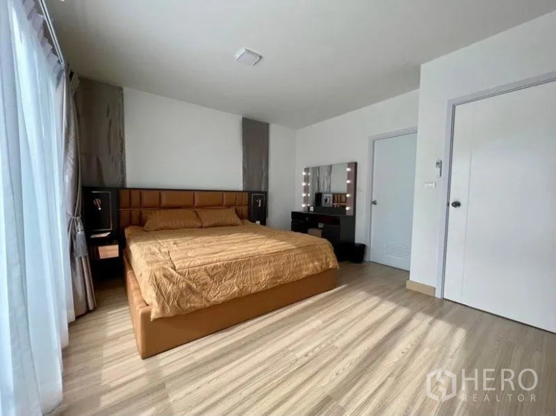 ทาวน์เฮาส์ ให้เช่าในWang Thonglang, Bangkok - ห้องนอนใหญ่ เตียงคิงไซส์ โต๊ะเครื่องแป้ง และพื้นลามิเนตลายไม้