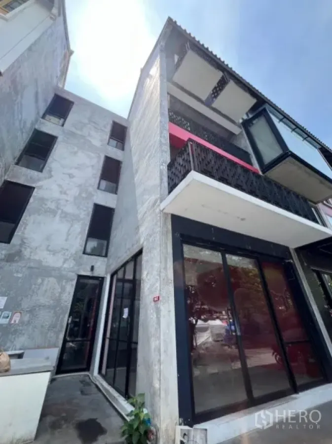 Retail Space for rent in Khlong Toei, Bangkok - Angular exterior of a four-storey building with balconies and a ground-floor shopfront.