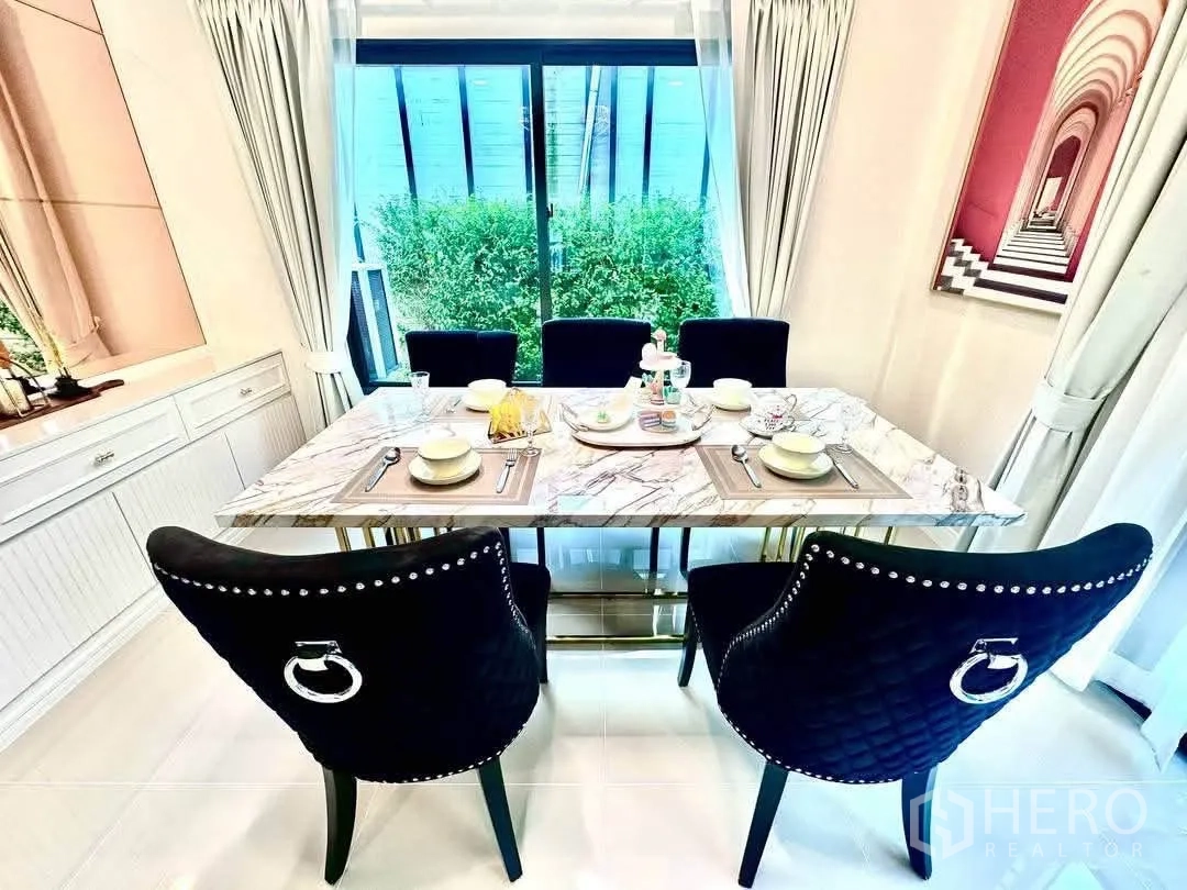 Detached House for rent in Bang Kapi, Bangkok - Close view of a marble dining table beside sliding glass doors to greenery.