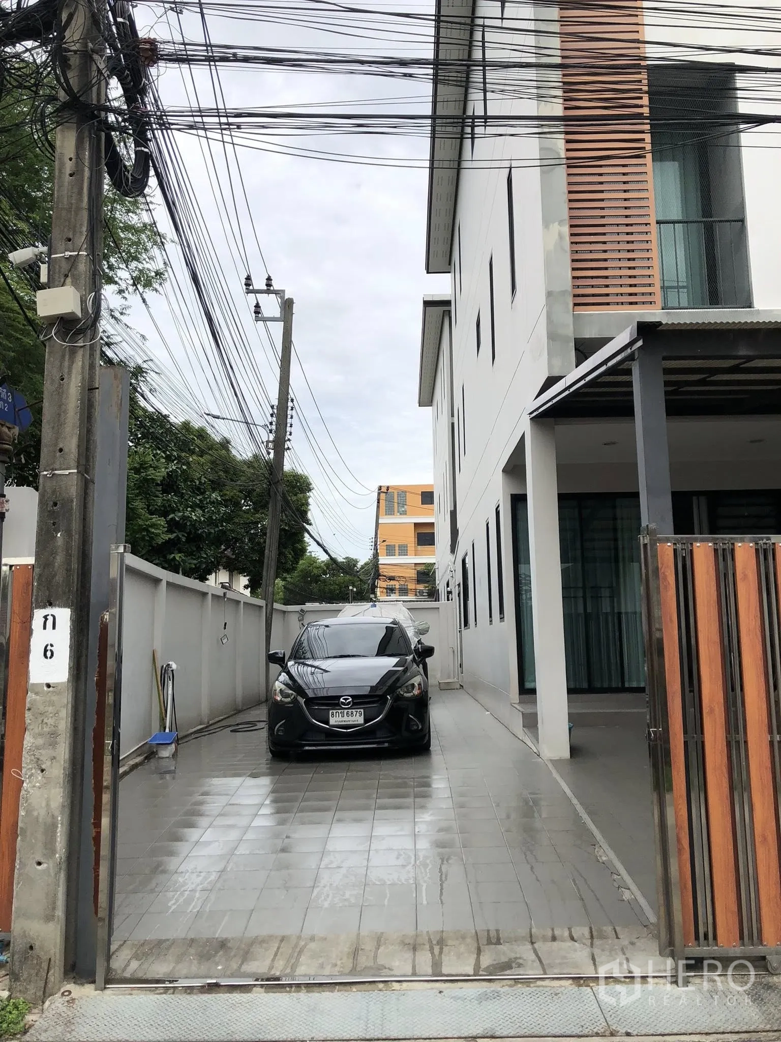 ทาวน์เฮาส์ ขายในPhra Khanong, Bangkok - ทางรถเข้า–ออกปูพื้นกระเบื้องยาวข้างตัวบ้าน จอดรถได้หลายคันหลังรั้วไม้