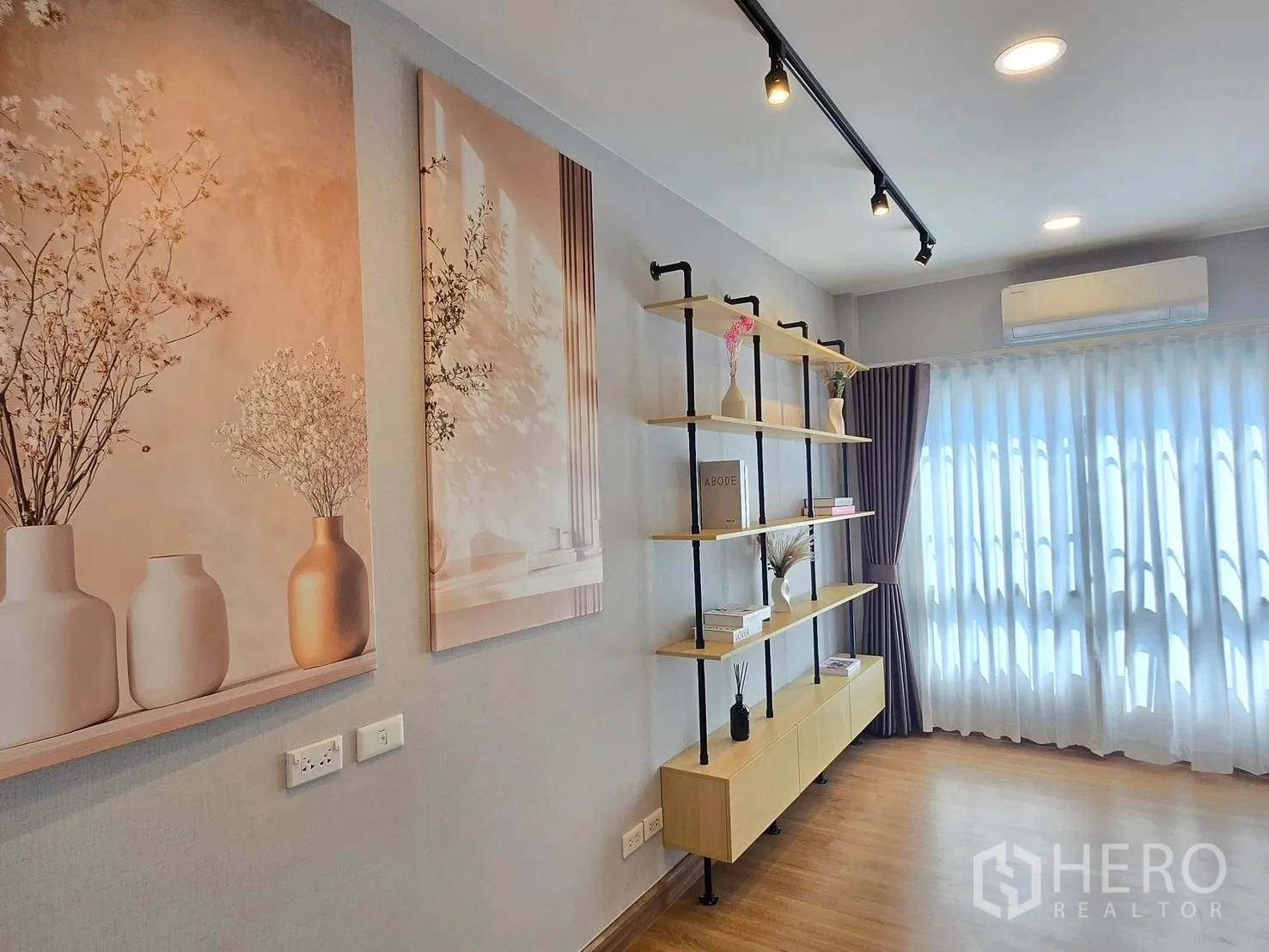 Detached House for rent or sale in Bang Phli, Samut Prakan - Bright multipurpose room with track lighting, wall art, open shelving and large windows.
