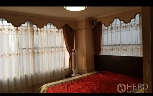 คอนโด ให้เช่าหรือขายในWatthana, Bangkok - ห้องนอนมุมกระจกบานใหญ่ ผ้าม่านสองชั้น และเตียงปูผ้าปูสีแดง