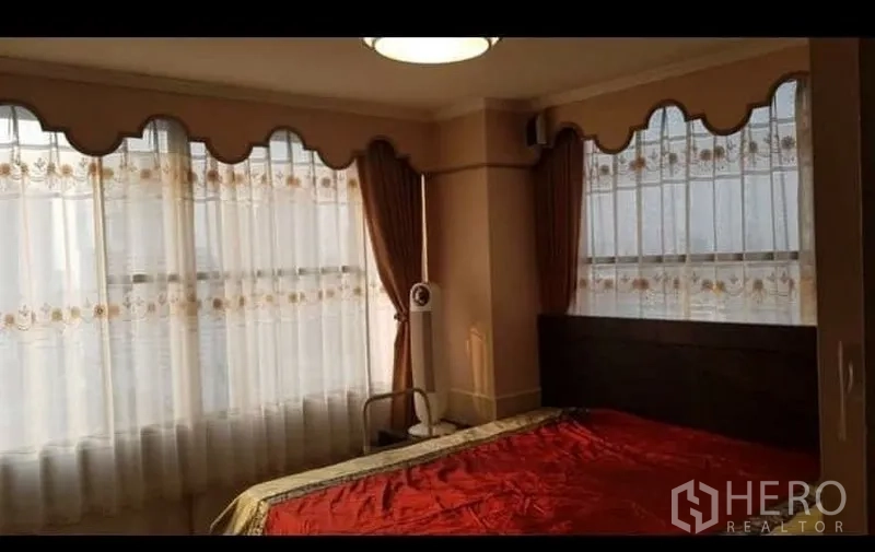 คอนโด ให้เช่าหรือขายในWatthana, Bangkok - ห้องนอนมุมกระจกบานใหญ่ ผ้าม่านสองชั้น และเตียงปูผ้าปูสีแดง