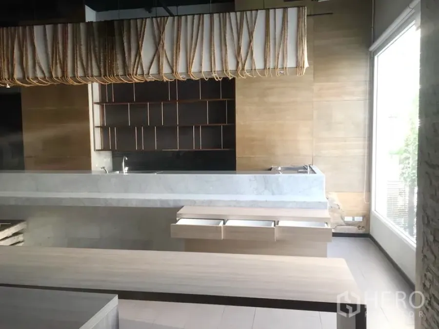 零售空间 出租在Khlong Toei, Bangkok - 现代零售内饰，带大理石服务台、木质置物架与落地窗