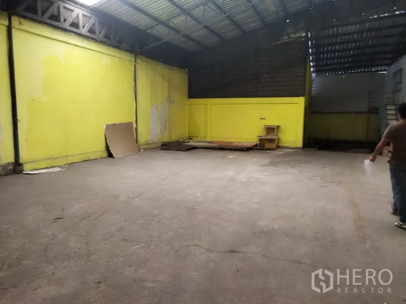 Warehouse for rent in Khlong Sam Wa, Bangkok - Open storage bay with yellow walls, metal roof and clear concrete floor ideal for staging or light operations.