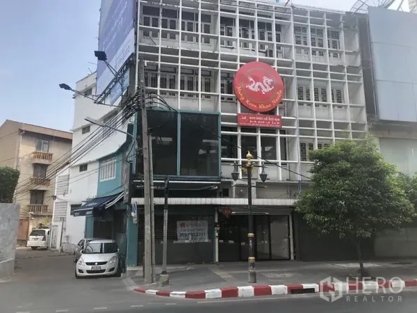 零售空间 出租在Khlong Toei, Bangkok - 素坤逸支路上的转角商铺楼，网格立面与醒目圆形招牌。