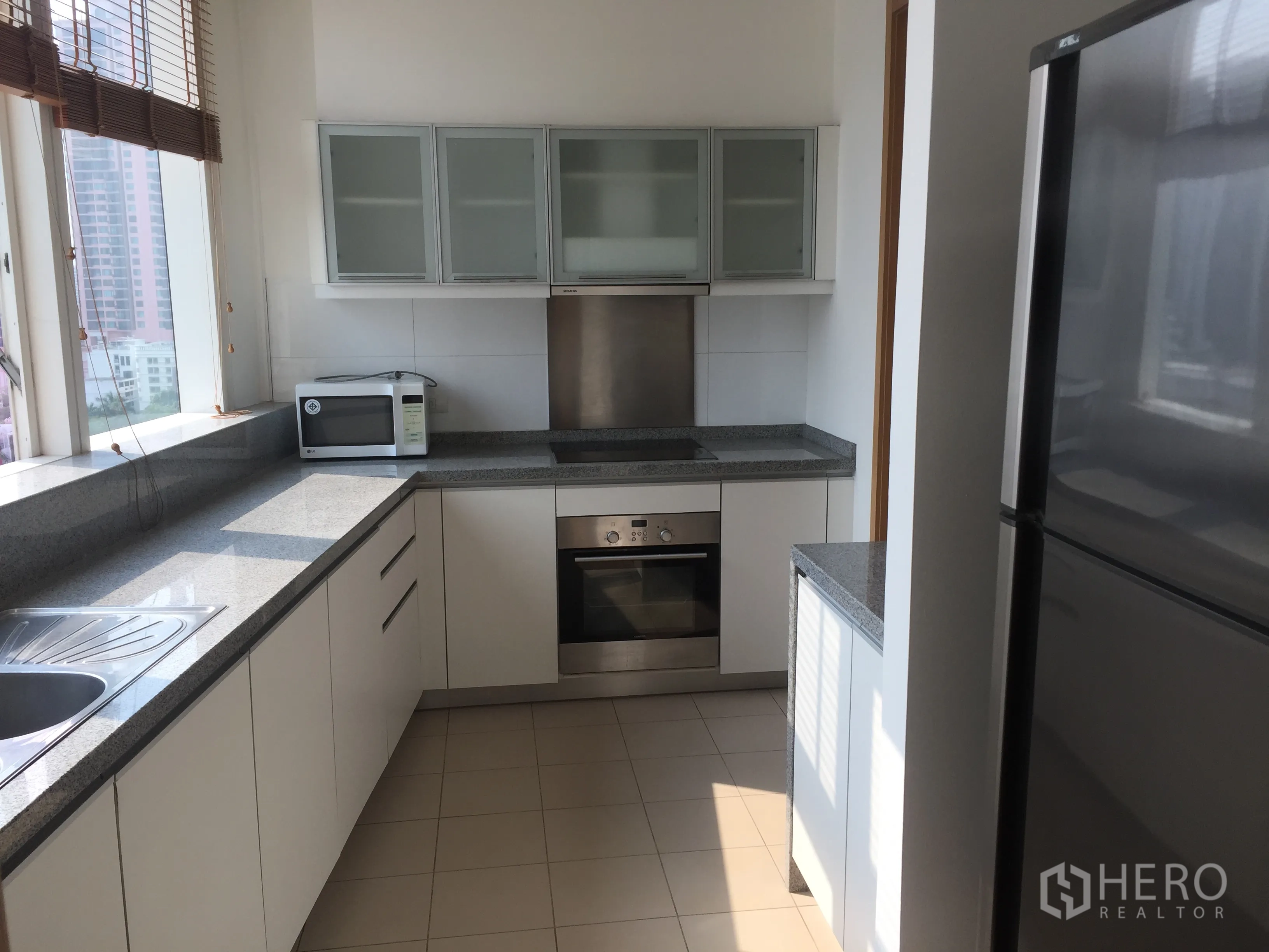 คอนโด ให้เช่าในKhlong Toei, Bangkok - ครัวปิดสไตล์โมเดิร์น เคาน์เตอร์หินแกรนิต ตู้สีขาว เตาอบ ไมโครเวฟ และหน้าต่างบานใหญ่