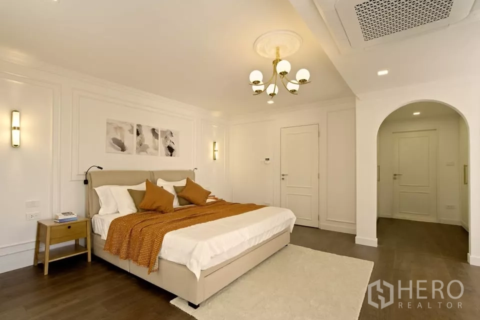 คอนโด ขายในWatthana, Bangkok - ห้องนอนหลักในคอนโดกรุงเทพฯ โคมไฟระย้า ผนังบัว ตกแต่งโทนอุ่น