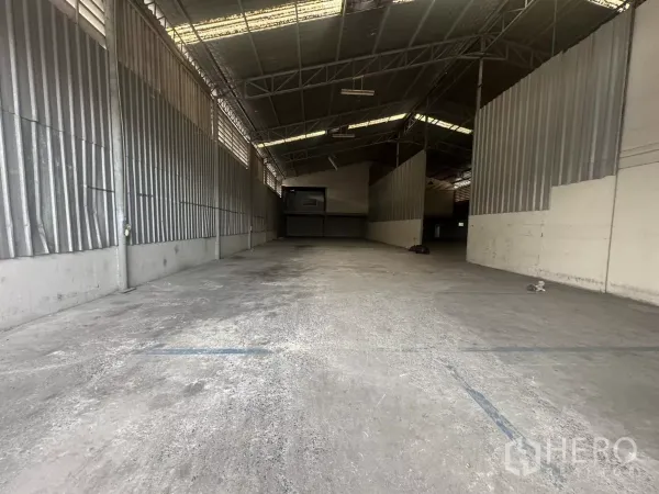 Warehouse for rent in Suan Luang, Bangkok - Spacious warehouse bay with high steel trusses, concrete floor and corrugated side walls.