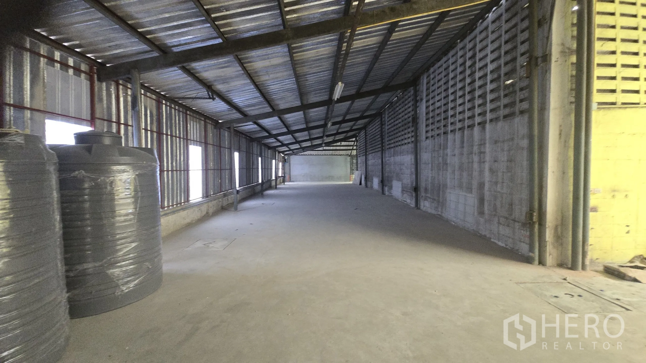 Warehouse for rent in Khlong Sam Wa, Bangkok - Extended storage area with metal sheet walls, concrete floor and strip lighting.