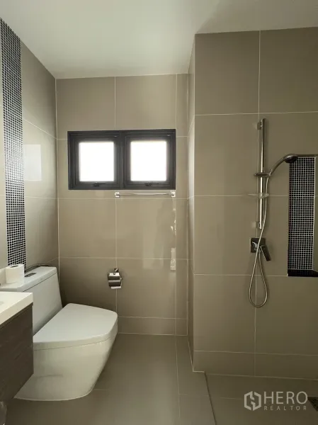 Detached House for sale in Suan Luang, Bangkok - Ground-floor bathroom with walk-in shower and beige wall tiles.