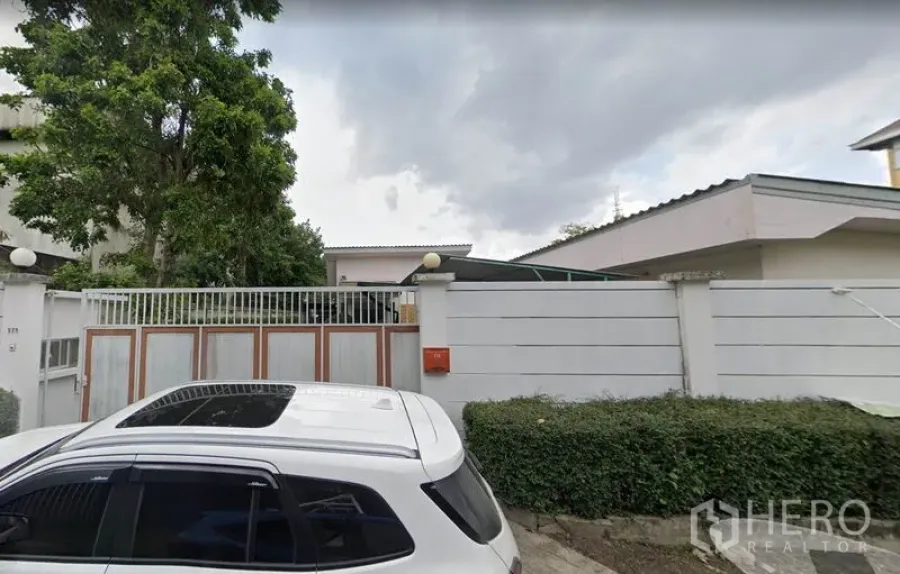 สำนักงานที่บ้าน ให้เช่าในLat Phrao, Bangkok - มุมมองหน้าซอยของโฮมออฟฟิศ มีกำแพงสีขาวสูงและประตูเลื่อนโลหะในย่านลาดพร้าว