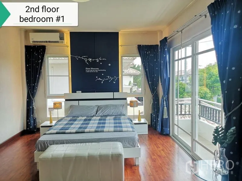 บ้าน ให้เช่า - ห้องนอนใหญ่หันหน้าออกระเบียง ผ้าม่านสีน้ำเงิน ประตูกระจกบานเลื่อน และพื้นไม้