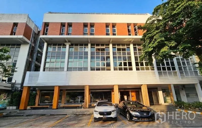 店屋 出租或出售在Khlong Toei, Bangkok - 艾卡迈曼谷玻璃与砖立面的四层商铺外观，配有停车位。