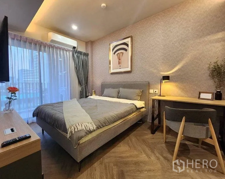 Condominium for rent in Bang Rak, Bangkok - Primary bedroom with city-view window, study desk and warm ambient lighting.