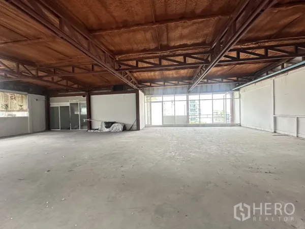 พื้นที่ขายปลีก ให้เช่าในWatthana, Bangkok - ห้องมุมสว่างโปร่ง พร้อมกระจกบานใหญ่ เพดานโครงเหล็ก และพื้นปูนดิบ