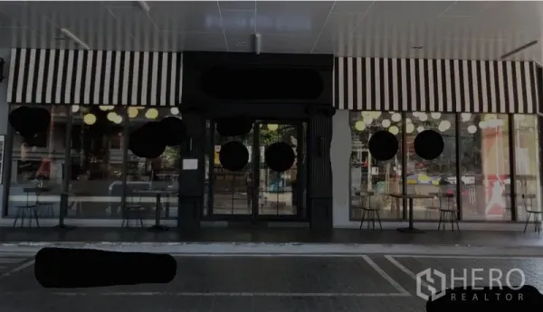 พื้นที่ขายปลีก ให้เช่าในKhlong Toei, Bangkok - หน้าร้านค้าระดับพื้นดิน มีกันสาดลายขาวดำ กระจกเต็มบาน และที่นั่งคาเฟ่ ใกล้ BTS ทองหล่อ ย่านสุขุมวิท กรุงเทพฯ