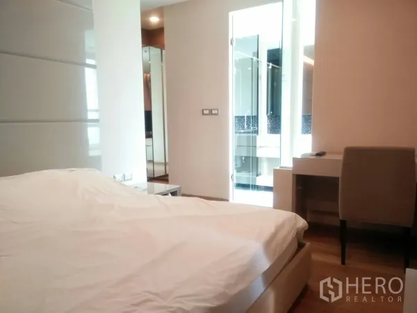 Condominium for rent in Ratchathewi, Bangkok - Bright bedroom with writing desk, wooden floors and a glass door leading to the en-suite bathroom