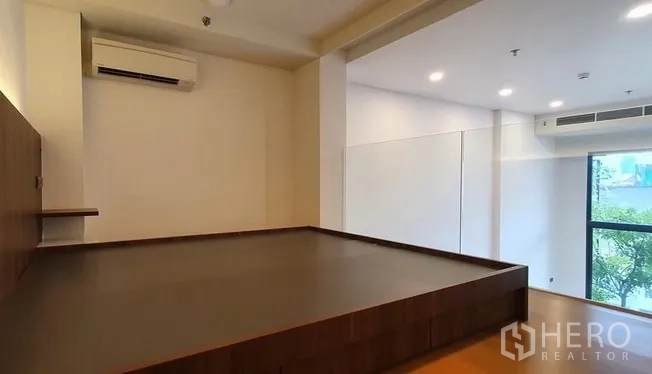 คอนโด ขายในWatthana, Bangkok - พื้นที่เตียงชั้นลอยกว้าง มีเครื่องปรับอากาศและหน้าต่างบานใหญ่เห็นวิวต้นไม้