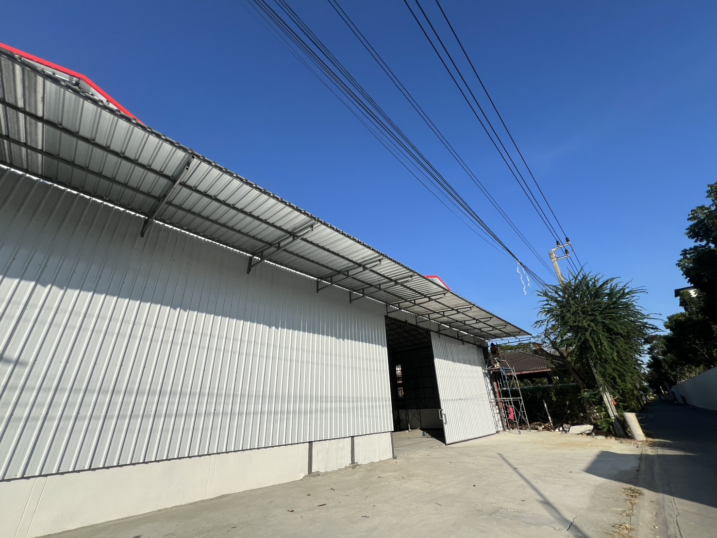 货栈 出租在Saphan Sung, Bangkok - 金属波纹外墙与推拉门上方雨棚的近景，曼谷沙攀颂仓库。