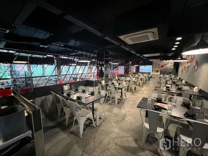 店屋 出租或出售在Khlong Toei, Bangkok - 餐区带涂鸦墙、红色座椅和冷藏展示柜。