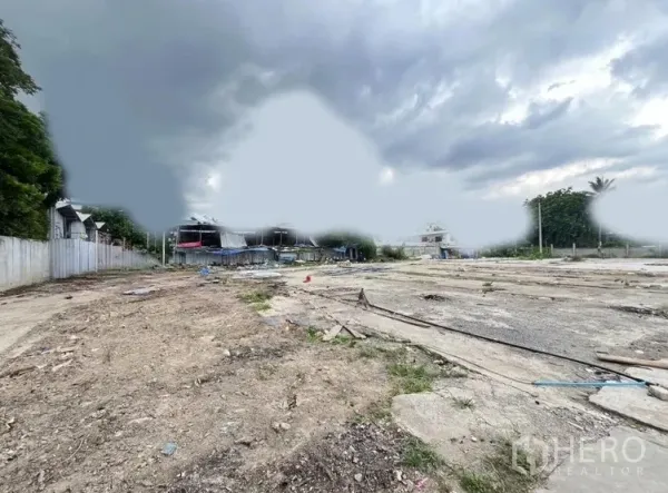 ที่ดิน ให้เช่าในKhlong Toei, Bangkok - ที่ดินว่างกว้าง พื้นดินปนคอนกรีต รั้วสองฝั่ง ท้องฟ้าครึ้ม
