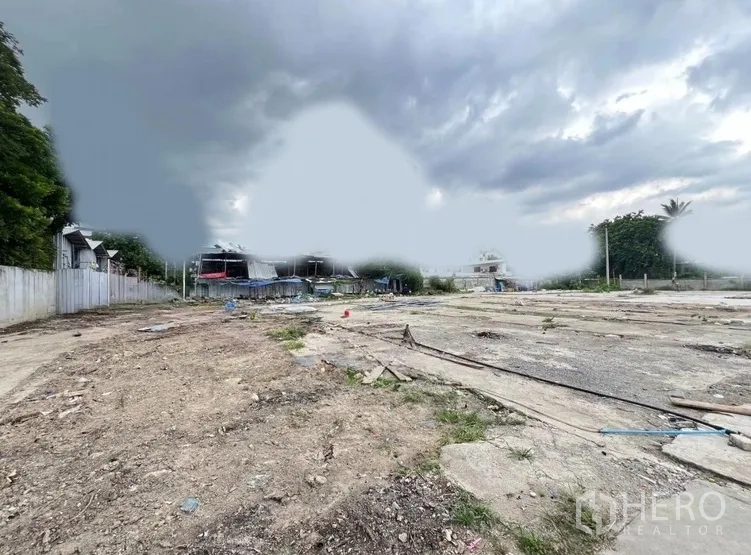 ที่ดิน ให้เช่าในKhlong Toei, Bangkok - ที่ดินว่างกว้าง พื้นดินปนคอนกรีต รั้วสองฝั่ง ท้องฟ้าครึ้ม