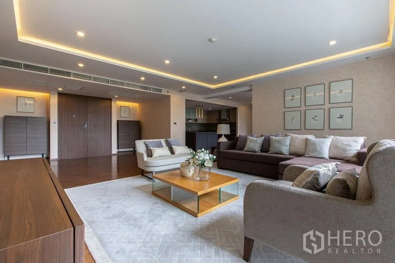 公寓 出售在Sathon, Bangkok - 开放式起居区，嵌灯天花与转角沙发，可望厨房。