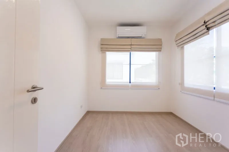 Townhouse for rent in Bang Phli, Samut Prakan - Sunlit spare room with wood floors, two corner windows and air conditioning.