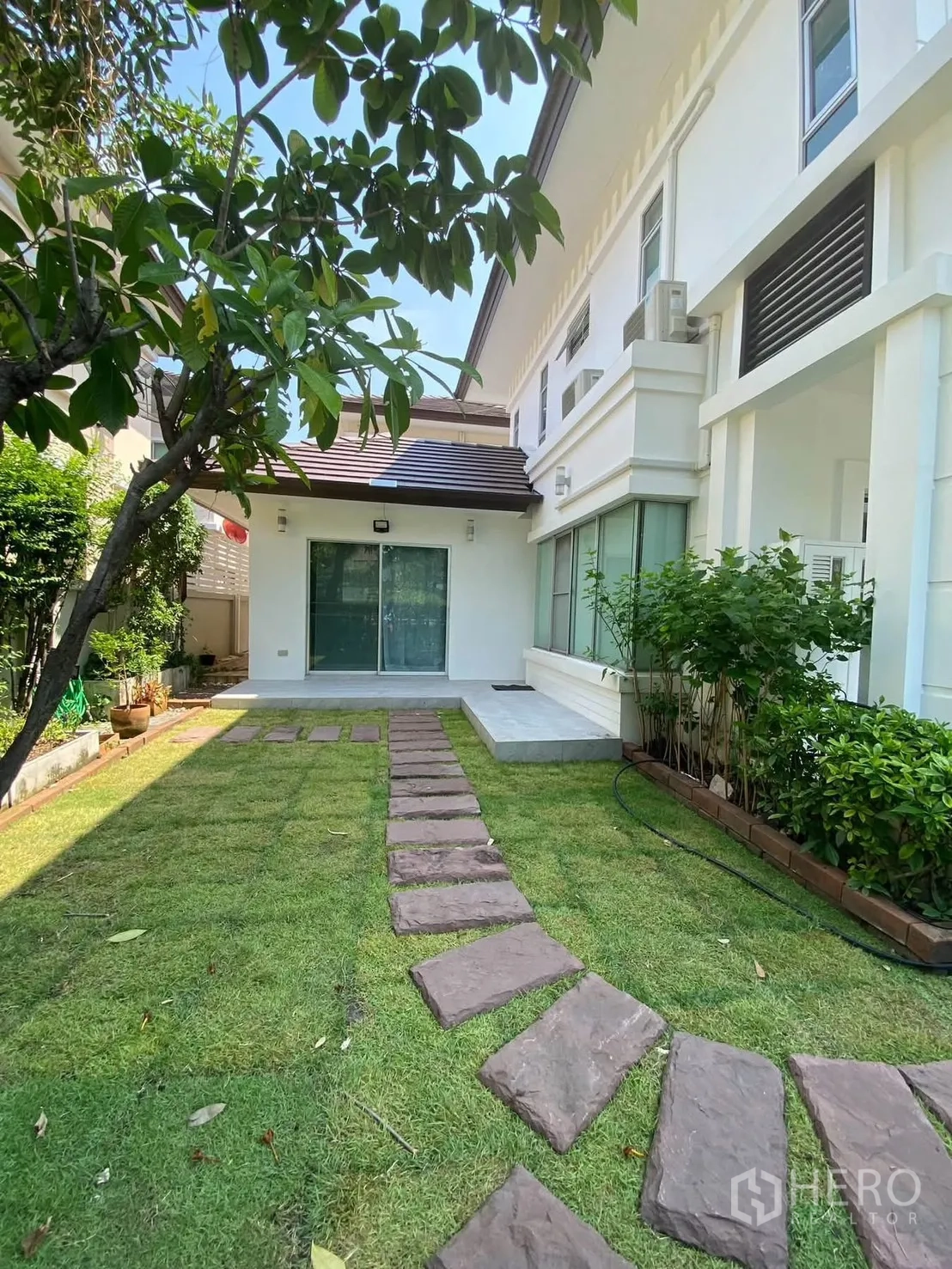 Detached House for rent in Mueang Samut Prakan, Samut Prakan - Backyard garden with grass and path leading to the terrace.