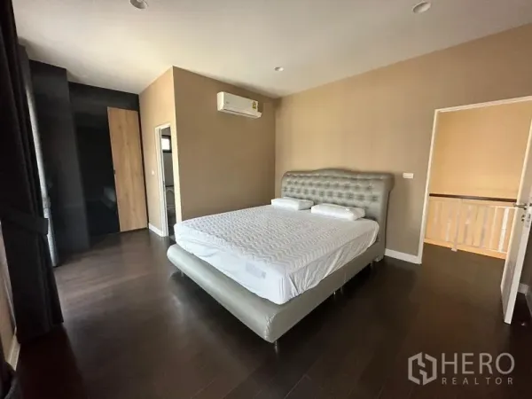 บ้าน ให้เช่าหรือขายในLam Luk Ka, Pathum Thani - ห้องนอนรองพร้อมเตียงหัวบุ เครื่องปรับอากาศ พื้นไม้เข้ม และตู้เสื้อผ้า