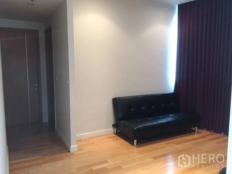 คอนโด ขายในKhlong Toei, Bangkok - มุมทำงานเงียบสงบ โซฟาหนังสีดำ ไฟดาวน์ไลท์ และผ้าม่านทึบสีม่วง