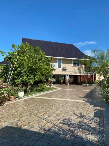 Detached House for sale in Bang Bo, Samut Prakan - Wide driveway and covered parking beside landscaped greenery.