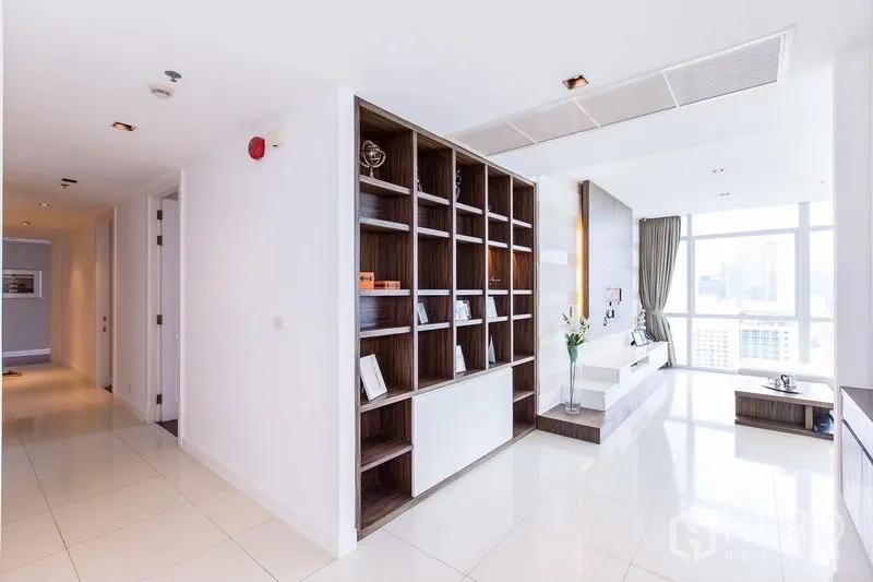Condominium for rent in Pathum Wan, Bangkok - Feature open shelving dividing corridor and living area in white interiors.