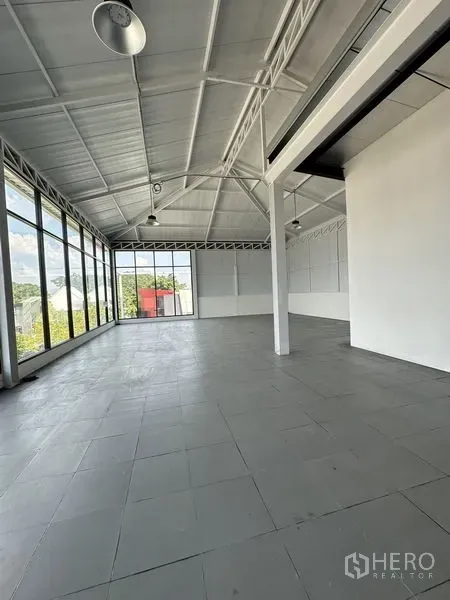 零售空间 出租在Bang Na, Bangkok - 明亮的开放式零售空间，挑高屋顶、灰色瓷砖地面与整面落地窗。