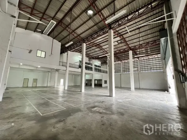 Warehouse for rent in Min Buri, Bangkok - Spacious high‑ceiling warehouse interior with steel columns and mezzanine level.