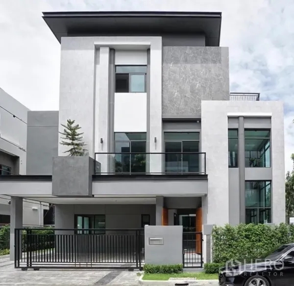 独立式住宅 出租或出售在Phra Khanong, Bangkok - 三层现代独栋别墅外立面，带阳台、大窗与带门车位。