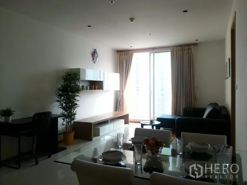 Condominium for rent in Sathon, Bangkok - Bright living and dining area with sofa, media console, and balcony access through floor-to-ceiling sliding doors.