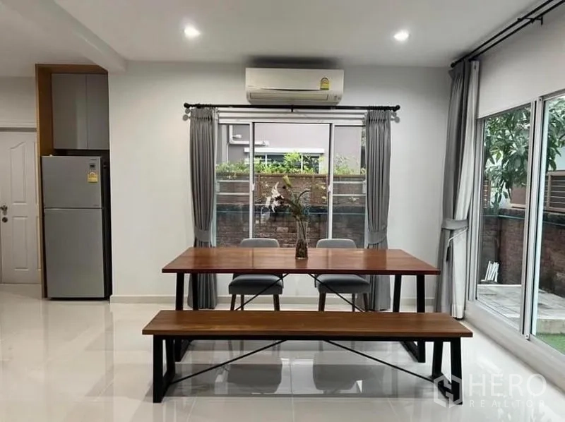 独立式住宅 出租在Suan Luang, Bangkok - 餐区，木质餐桌长椅，两侧皆有窗户