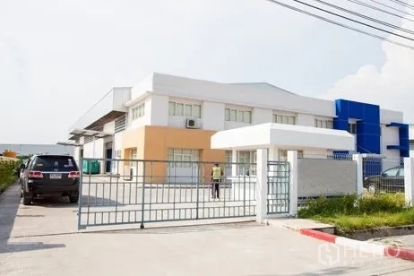 Factory for rent in Chachoengsao - Secure sliding gate and guard post at the factory entrance on the access road.