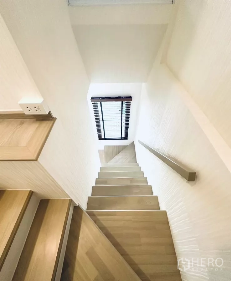 联排别墅 出租在Prawet, Bangkok - 浅木色楼梯，配扶手与采光窗。