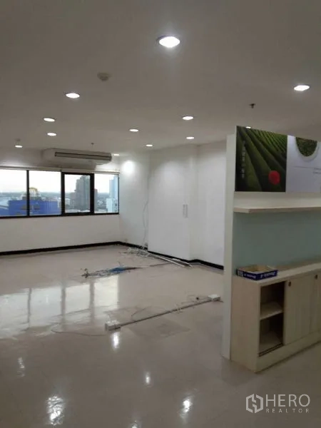 Office Space for rent in Watthana, Bangkok - Open office with cabinet display, large windows, ceiling lights, and loose network cabling.
